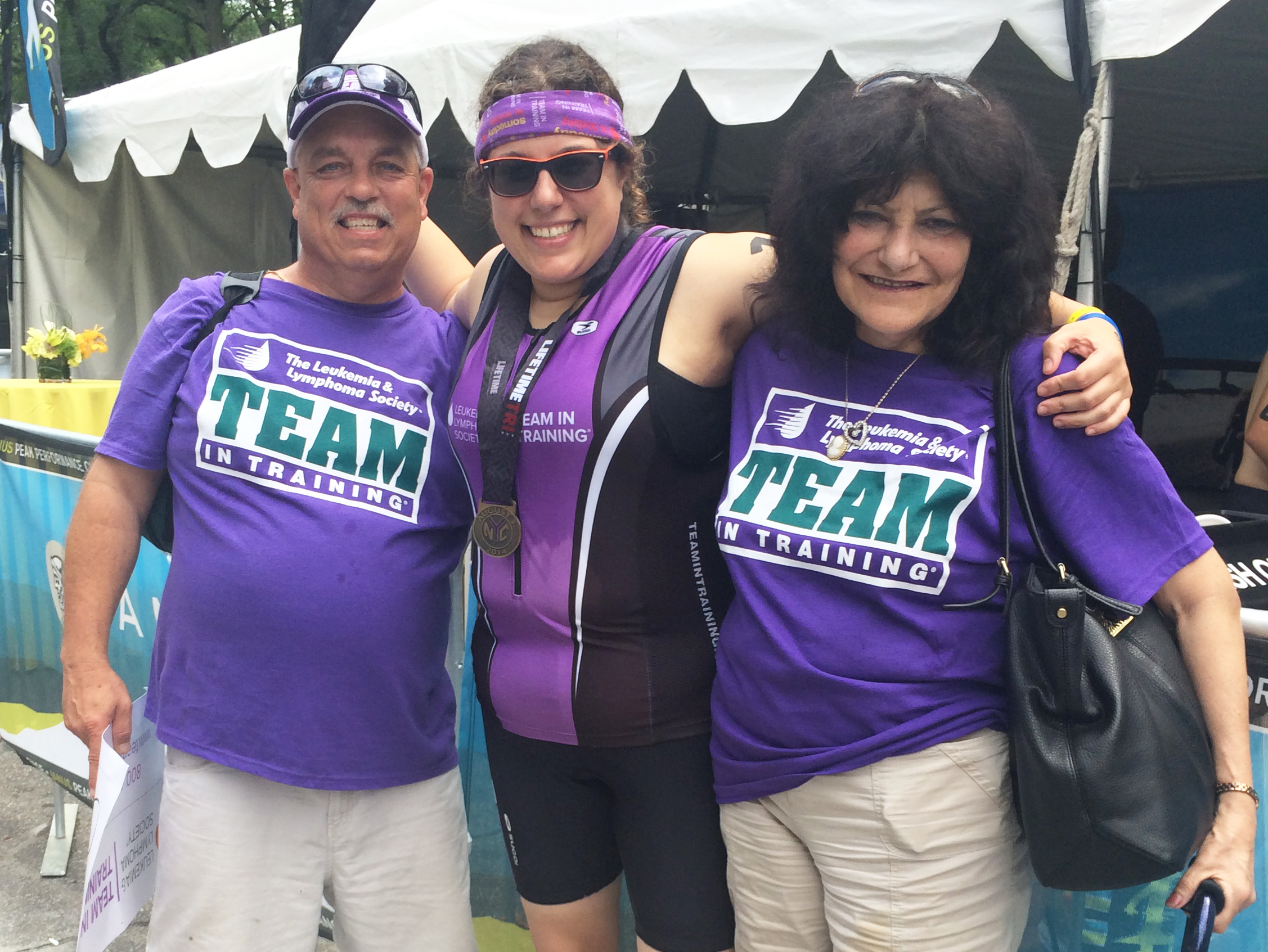 Carline with her parents at the finish line of her first triathlon